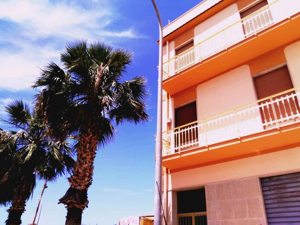 deux palmiers devant un bâtiment dans l'établissement Monolocale Rosina, à Trapani