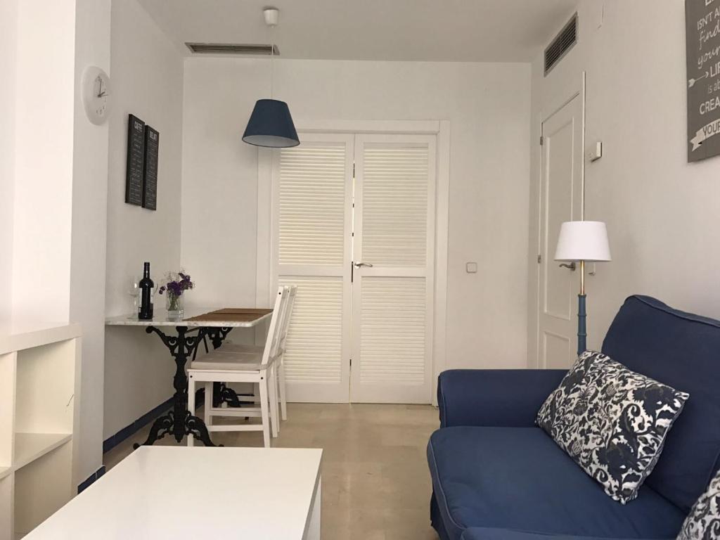 a living room with a blue couch and a table at CLB Apartamento Alameda in Seville