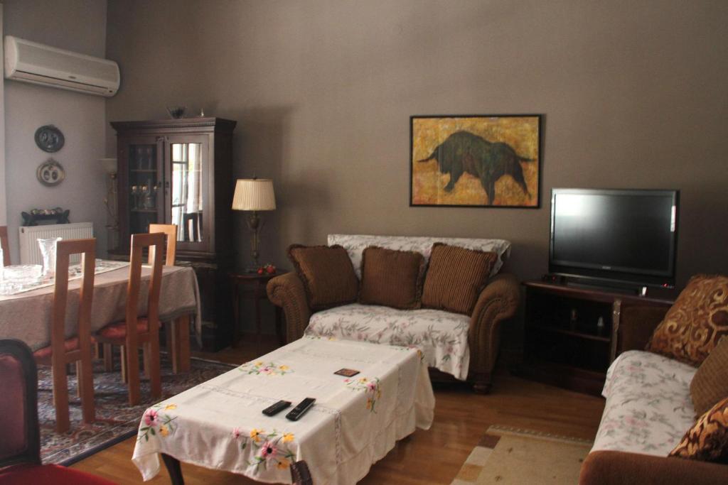 salon z kanapą i telewizorem w obiekcie Family house w Kalamácie