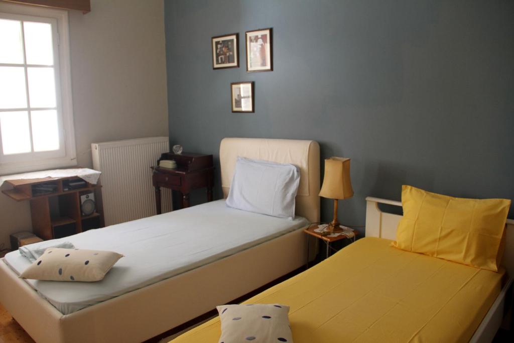 sypialnia z dwoma łóżkami i żółtymi poduszkami w obiekcie Family house w Kalamácie