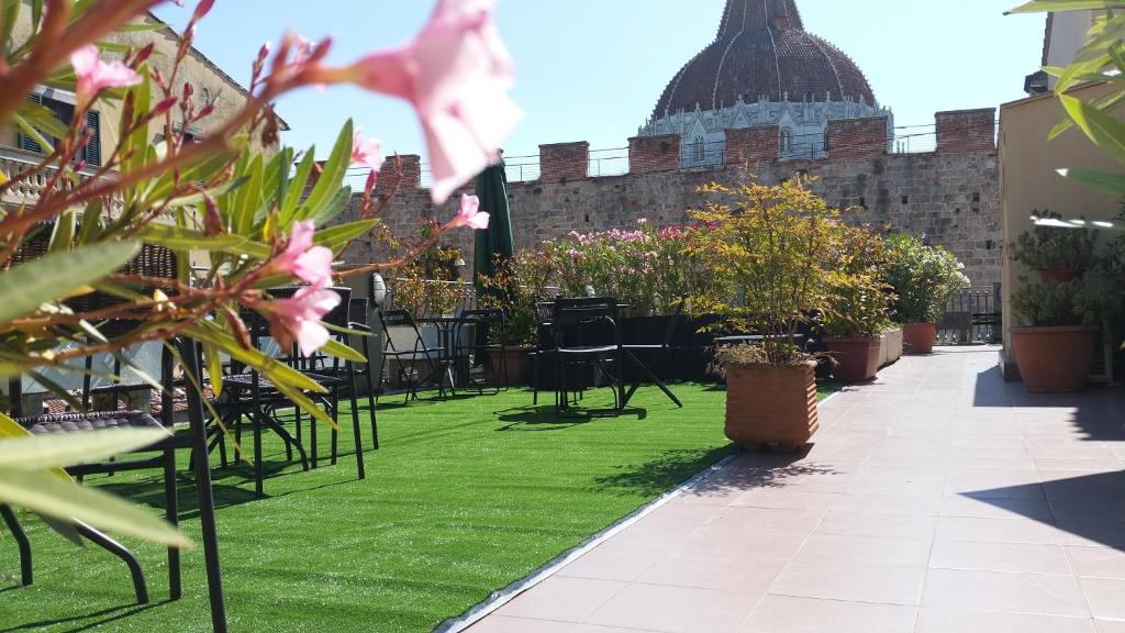 ピサにあるHotel Il Giardinoの草や椅子、植物のあるパティオ