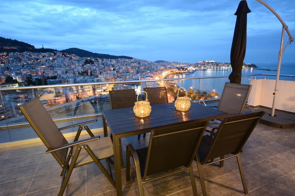 a table on a balcony with a view of a city at Verde Blue in Kavala