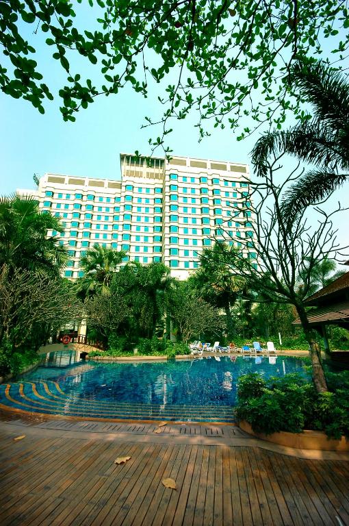 A landscaped outdoor pool framed by palms and the hotel tower.