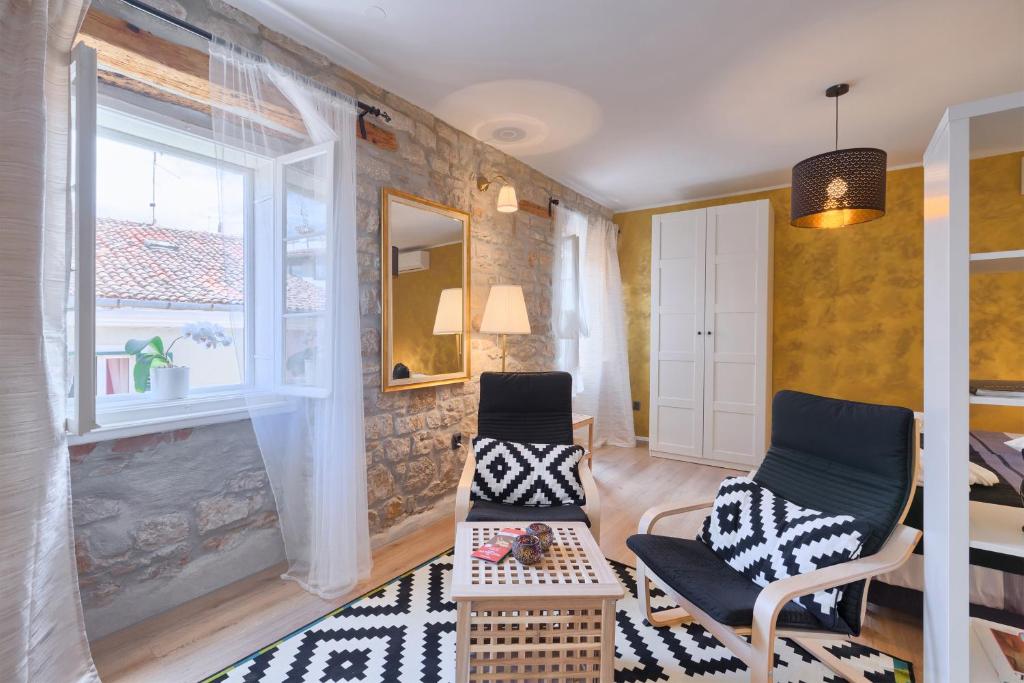 un soggiorno con 2 sedie e un tavolo di Luxury Apartment Fabris a Rovigno (Rovinj)