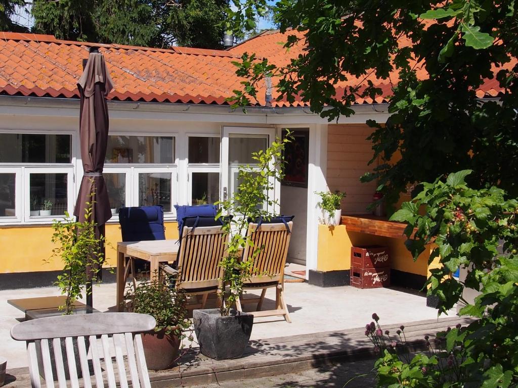un patio con mesa, sillas y sombrilla en Labaek B&B en Holbæk