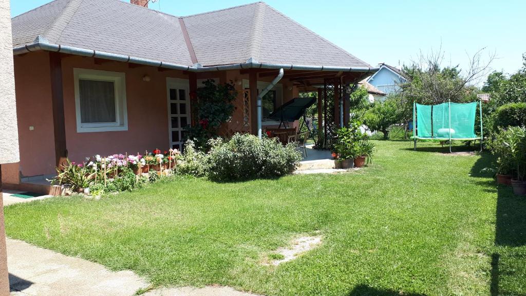 a small house with a yard with a green lawn at Németh Apartmanház in Balatongyörök