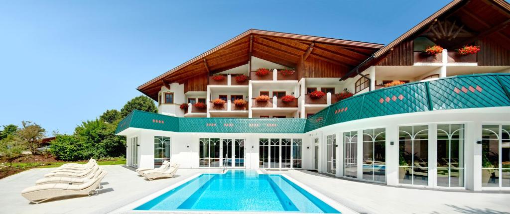a large house with a swimming pool in front of it at Hotel Neue Post in Bodenmais
