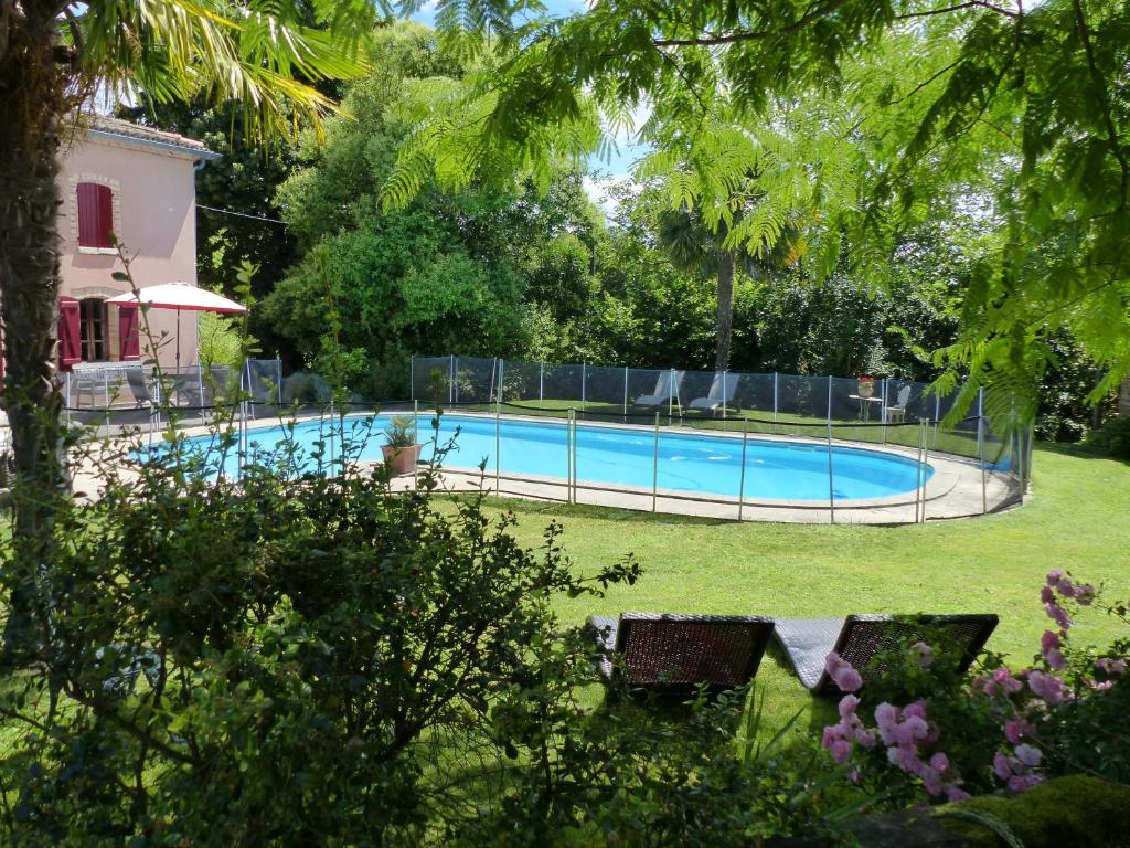 a swimming pool in the yard of a house at Chambres d'Hotes Au Val Dormant in Réalville