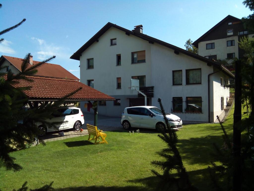 two cars parked in a yard in front of a building at Apartment Fon in Blejska Dobrava