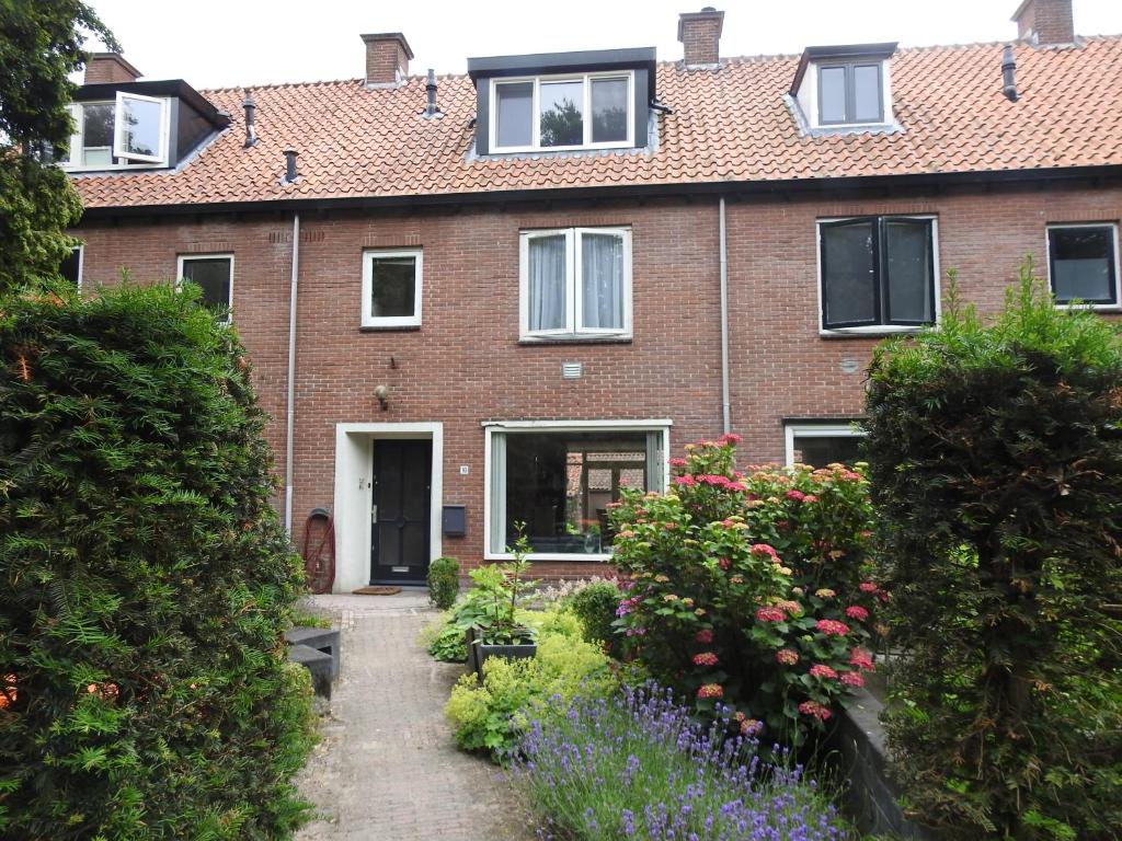 a brick house with a garden in front of it at MY-A-Mi-Go-S in Muiderberg