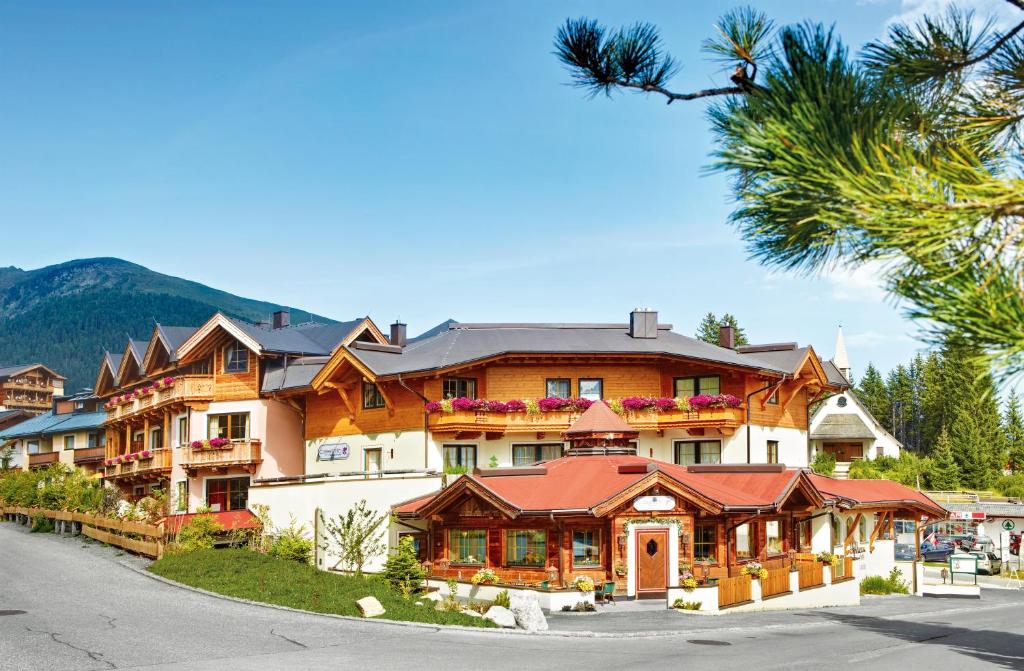 un hotel en las montañas con una palmera en Biohotel Castello Königsleiten en Königsleiten