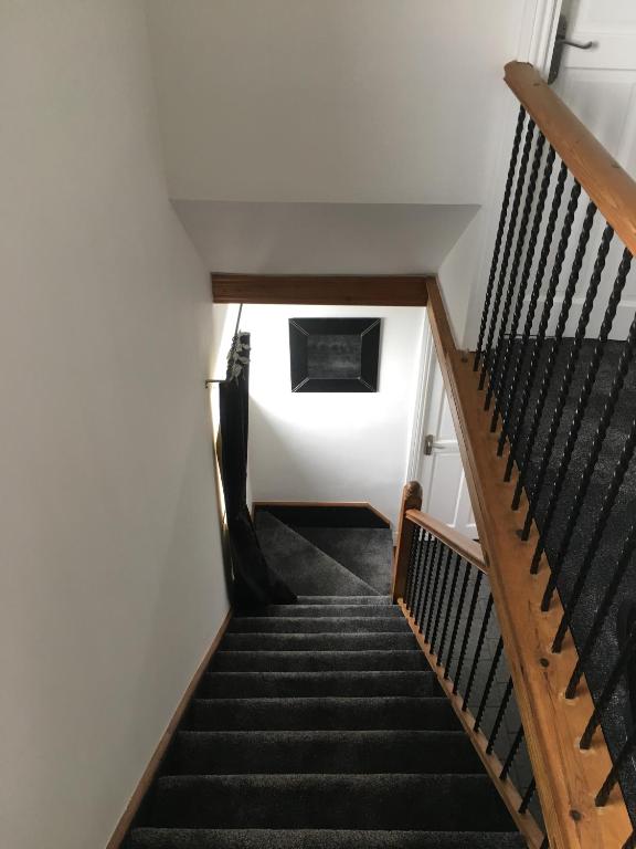 a stairway with black stairs and white walls at Craster Crew House in Craster