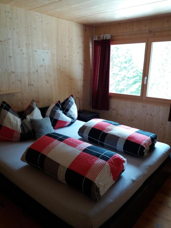 een slaapkamer met 2 bedden met kussens erop bij Jelmon Anstalt Restaurants Schneeflucht in Malbun