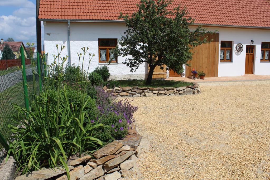 a garden in front of a house with a tree at Ubytovani Ve stodole in Stráž nad Nežárkou