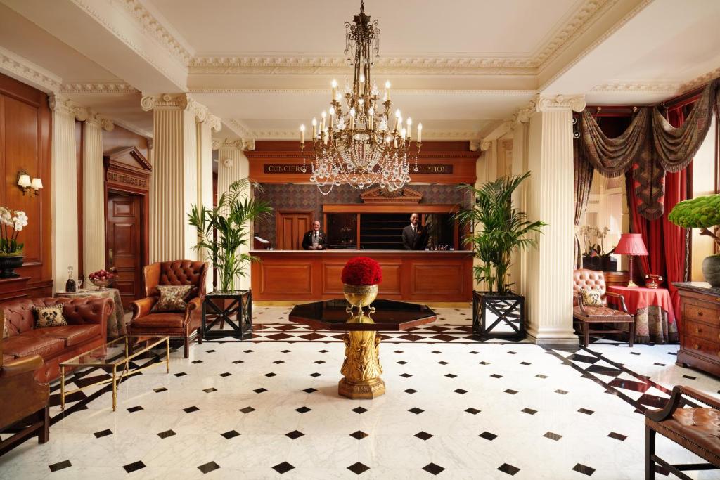 uma sala de estar com um lustre e uma mesa em The Chesterfield Mayfair em Londres