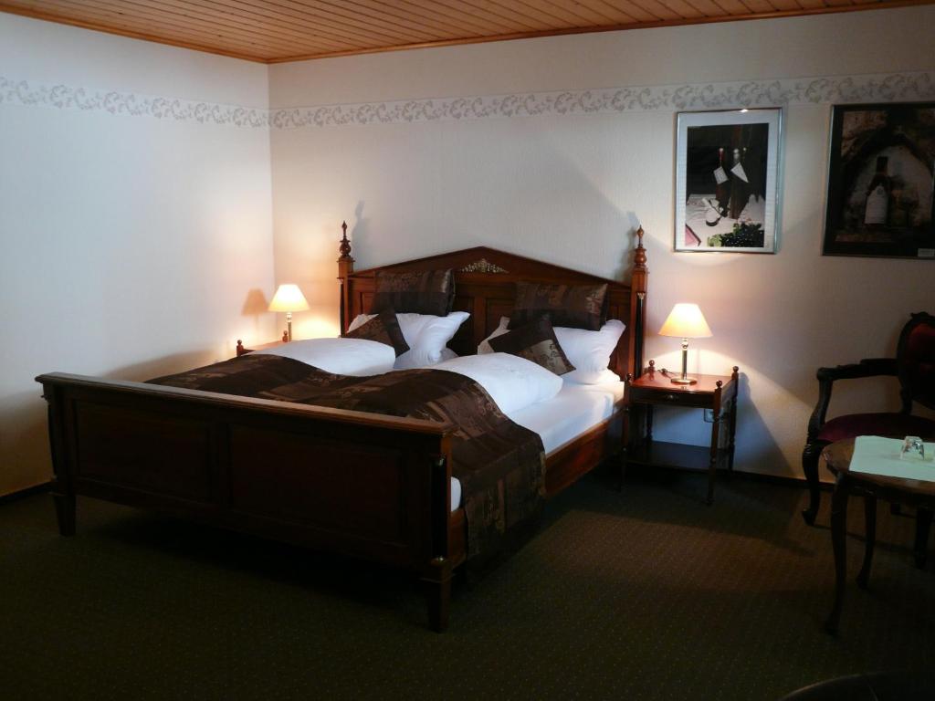 Weingasthof Zum weißen Roß في Osthofen: غرفة نوم بسرير كبير ومصباحين