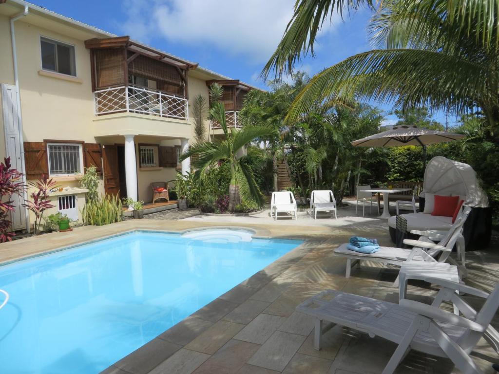 una piscina con sillas y una casa en Villa Kreola, en Grand Gaube