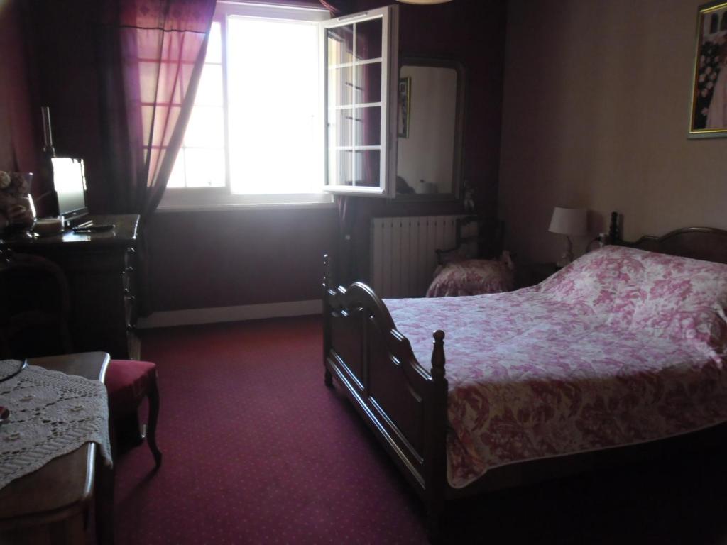 une chambre avec un lit et une fenêtre dans l'établissement La Luzacaise, à Saint-Just