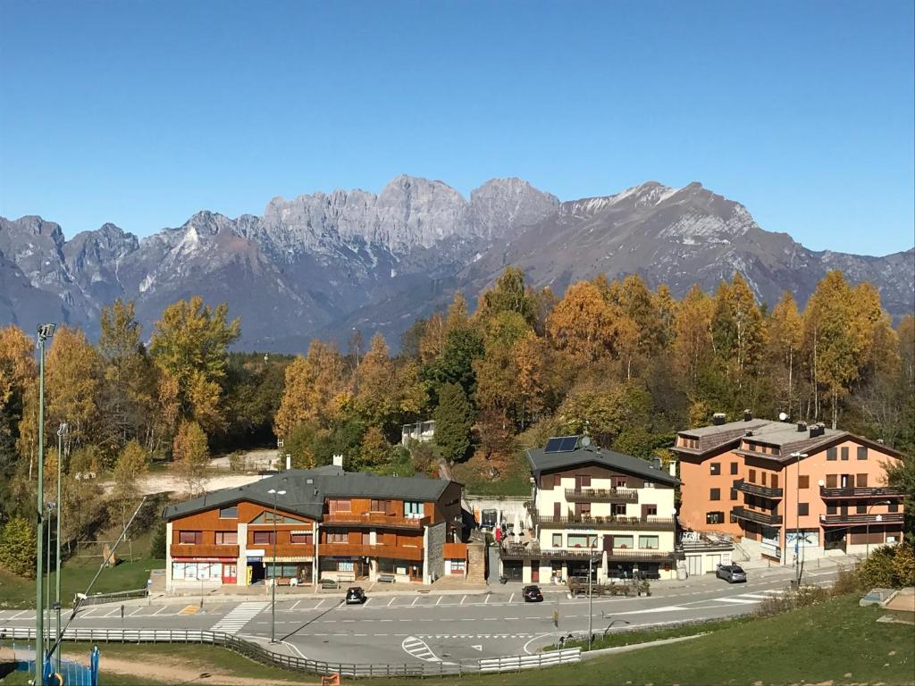 a building with a parking lot with mountains in the background at Albergo Slalom in Belluno