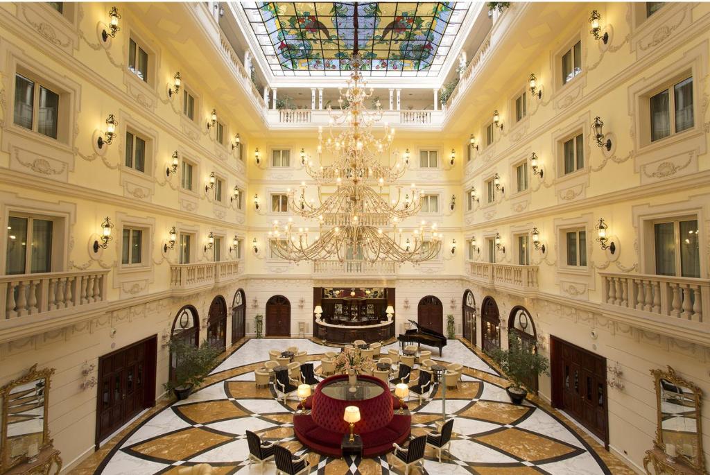 カゼルタにあるグランド ホテル ヴァンヴィテッリのシャンデリアが備わる広い客室です。