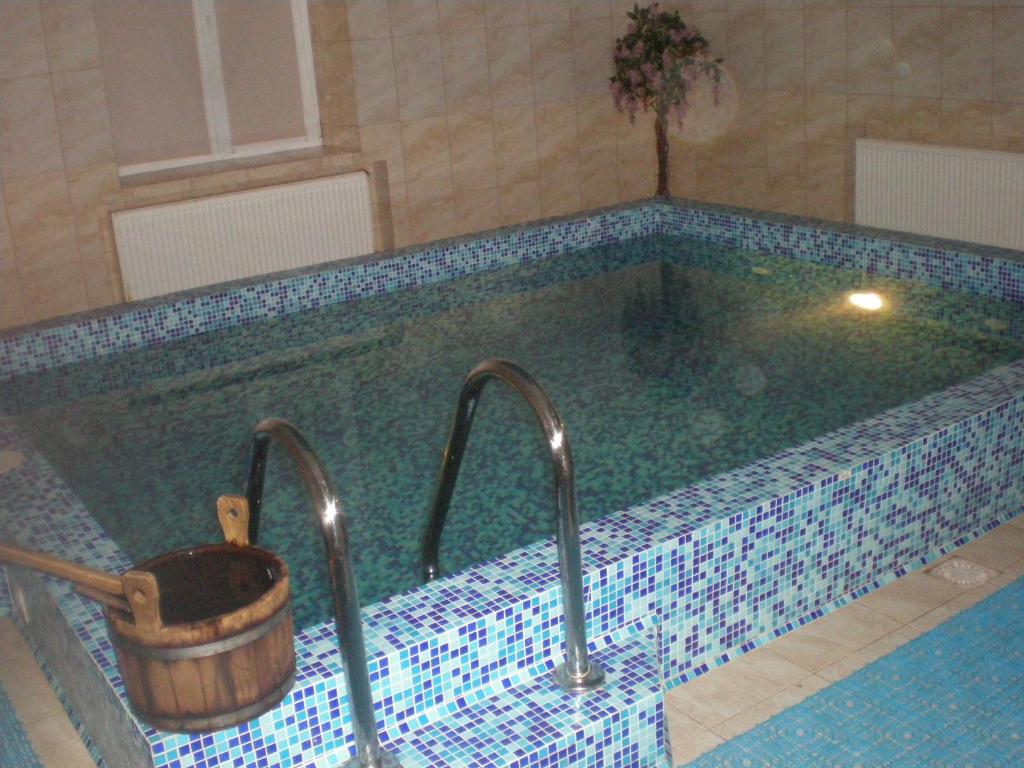 ein Schwimmbad mit zwei Wasserhähnen und einem Eimer in der Unterkunft Готельно- банний комплекс Афродіта in Nyzhni Mlyny