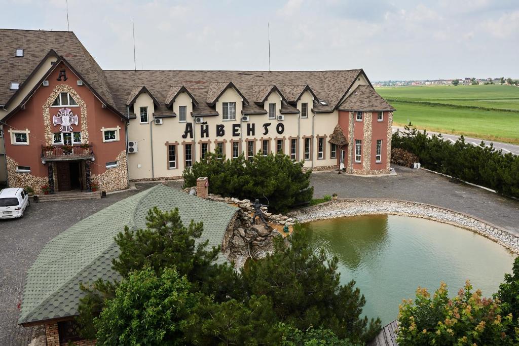 a large building with a pond in front of it at Aivengo Hotel in Rivne