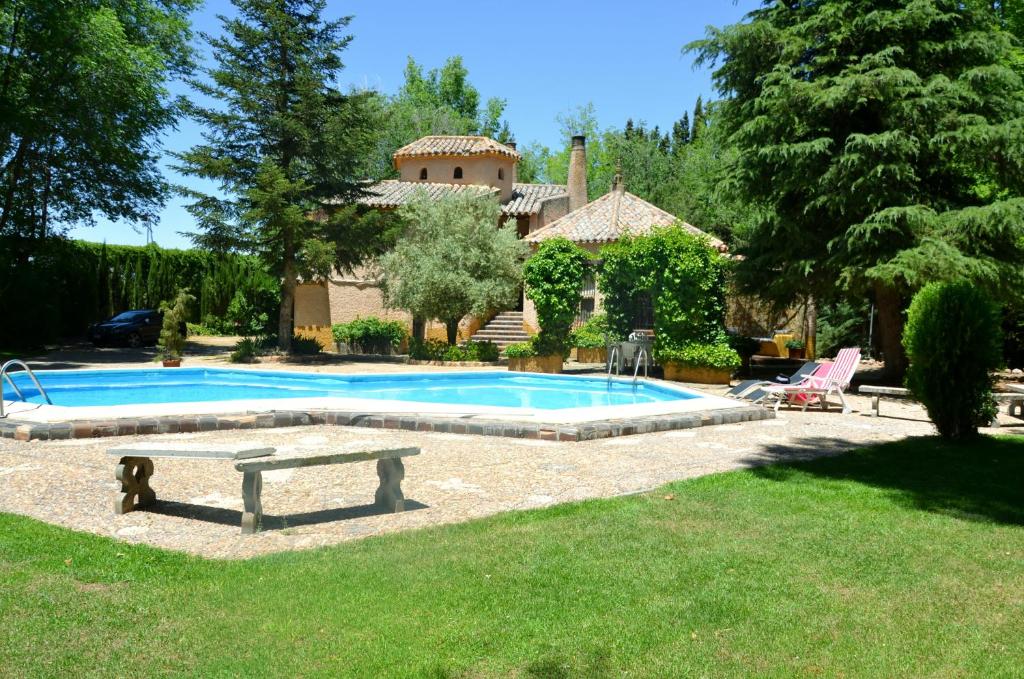a swimming pool in front of a house at Chalet rural en La Mancha con jardin y piscina privados in Tomelloso