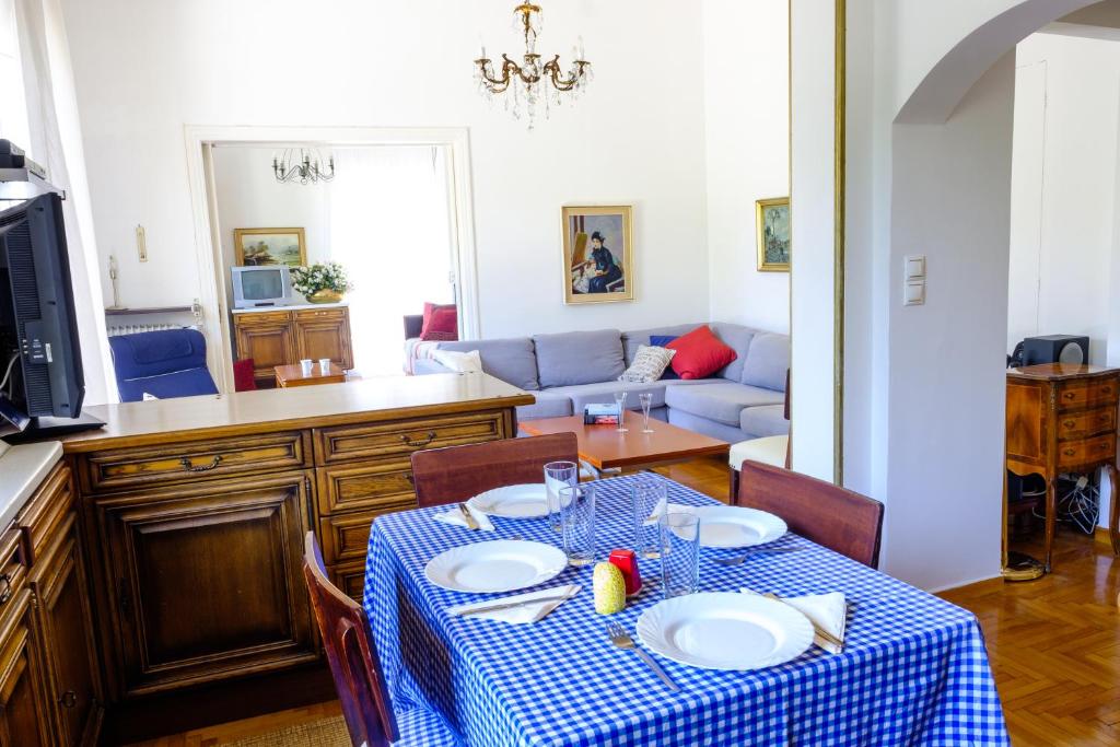 uma sala de estar com uma mesa e um sofá em Chalandri Home Away em Atenas