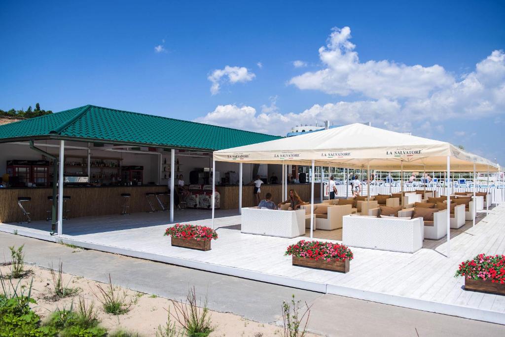 a pavilion with tables and chairs under a tent at Gold Bugaz Black Sea Hotel Group in Gribovka
