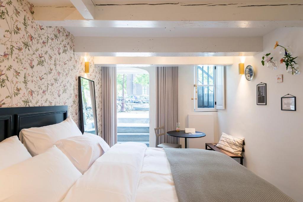 1 dormitorio con cama blanca y ventana en Milkhouse Luxury Stay Amsterdam, en Ámsterdam