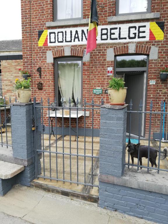 a black dog standing outside of a restaurant at La petite douane in Massembre