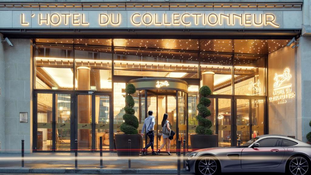Una pareja caminando en frente de una colección de hotel dmg en Hotel du Collectionneur, en París
