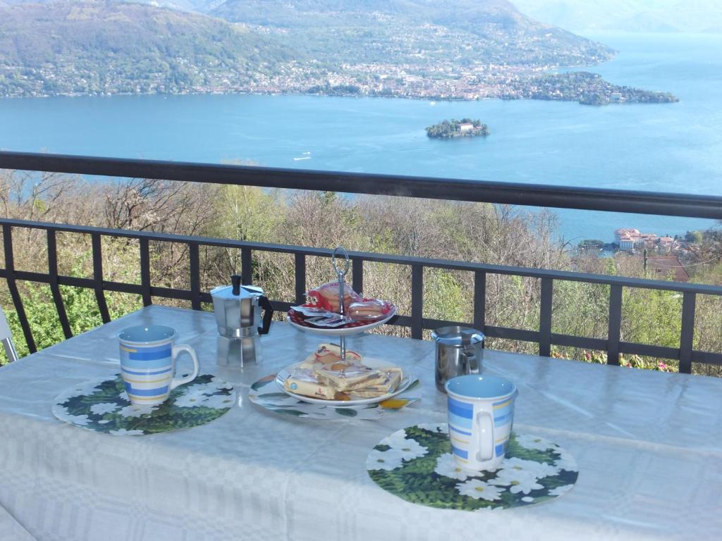 ein Tisch mit einem Teller Essen auf einem Balkon in der Unterkunft Appartamento Belvedere 4 in Stresa