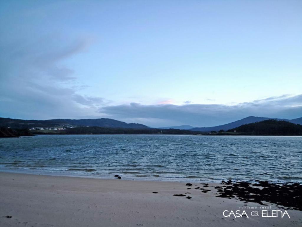 a beach with the ocean and mountains in the background at Casa Elena Turismo Rural in Reinante