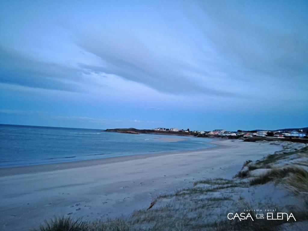 a sandy beach with houses and the ocean at Casa Elena Turismo Rural in Reinante