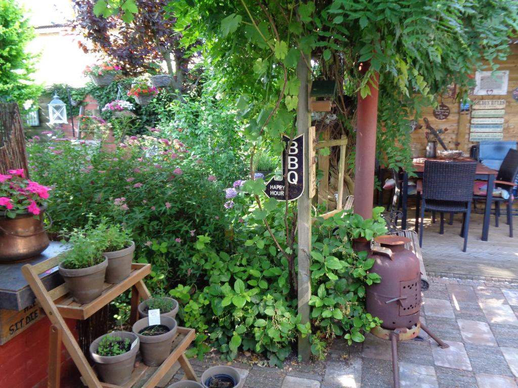 un jardín con macetas y un cartel en un poste en Oddingsplace en Hardenberg