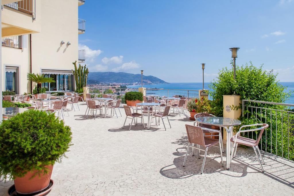 a patio with tables and chairs and the ocean at Hotel Metropol in Diano Marina