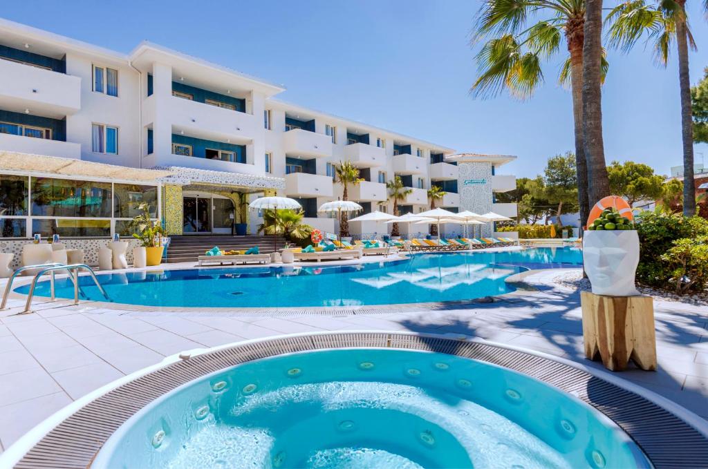 a resort pool with a hotel in the background at Sotavento Club Apartments - Adults Only in Magaluf