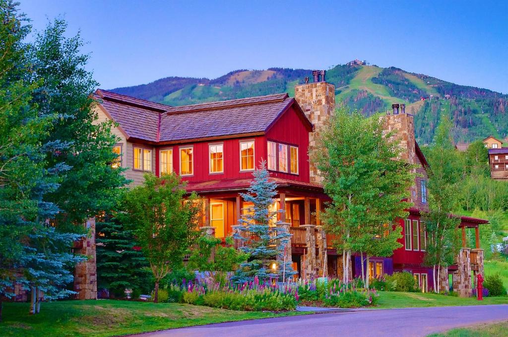 a large red house with a mountain in the background at The Porches in Steamboat Springs
