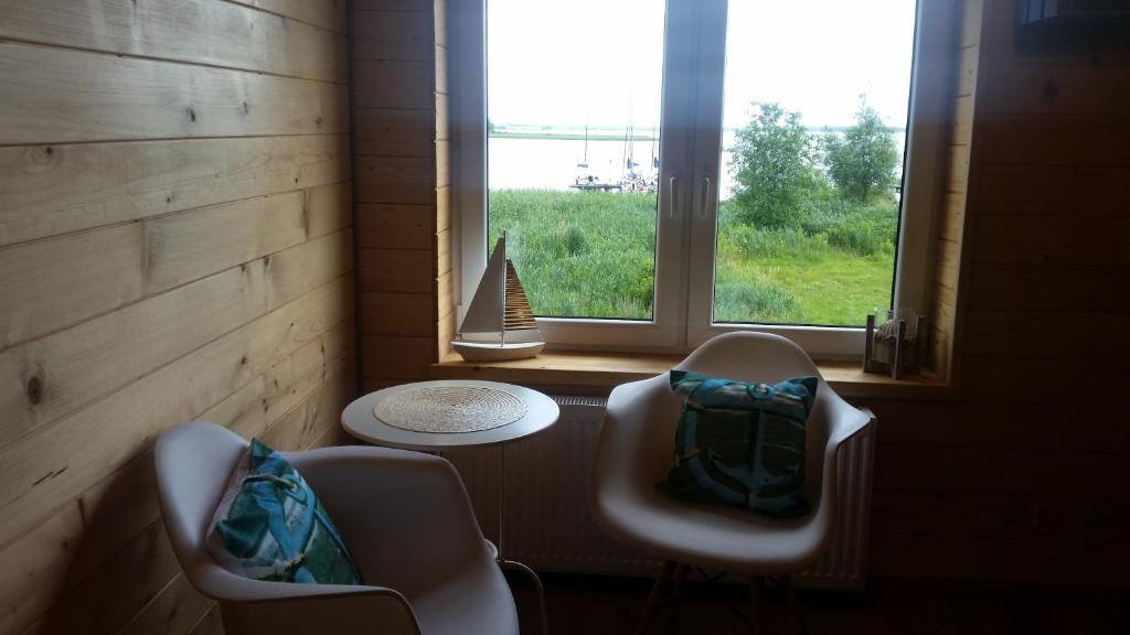 ビルカシにあるApartament nad jezioremの椅子2脚と景色を望む窓が備わる客室です。