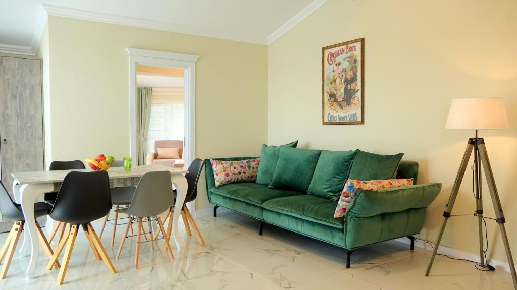 a living room with a green couch and a table at Villa Florance in Nesebar