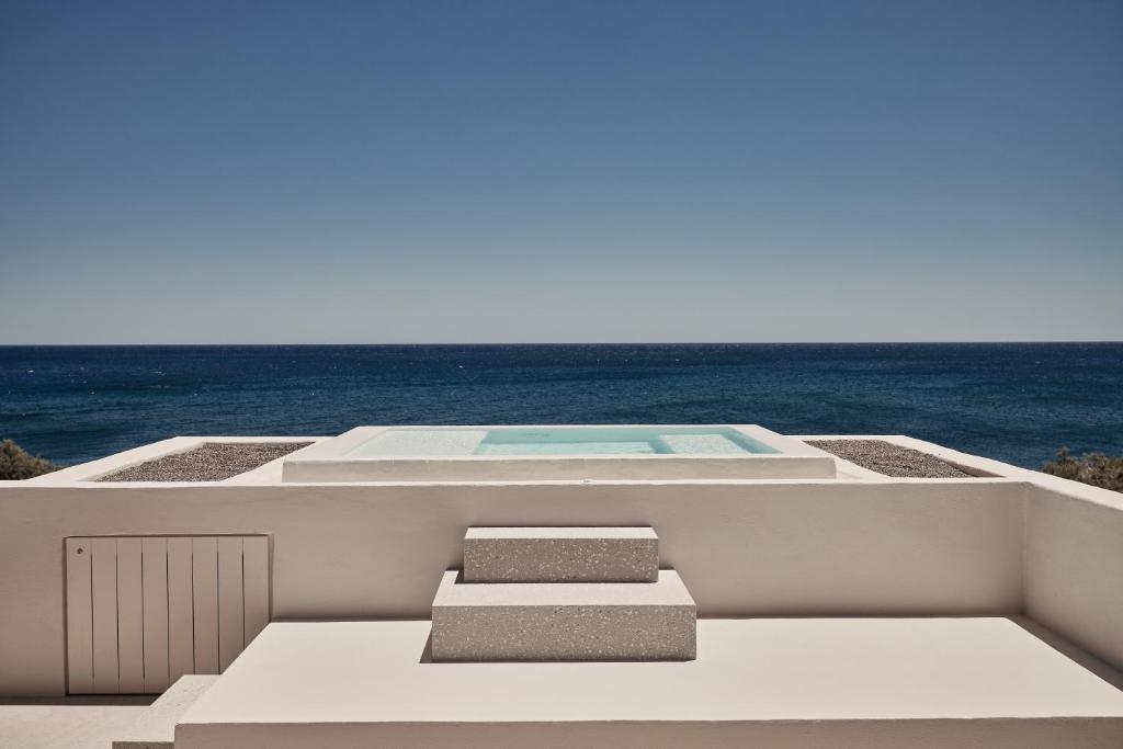 a swimming pool on the deck of a house at Istoria, a Member of Design Hotels in Perivolos