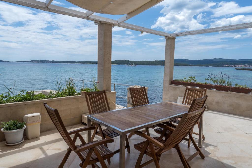 stół i krzesła na patio z widokiem na wodę w obiekcie Beachfront 4-bedroom villa Sea Wave in Orebic, Croatia w Orebiciu