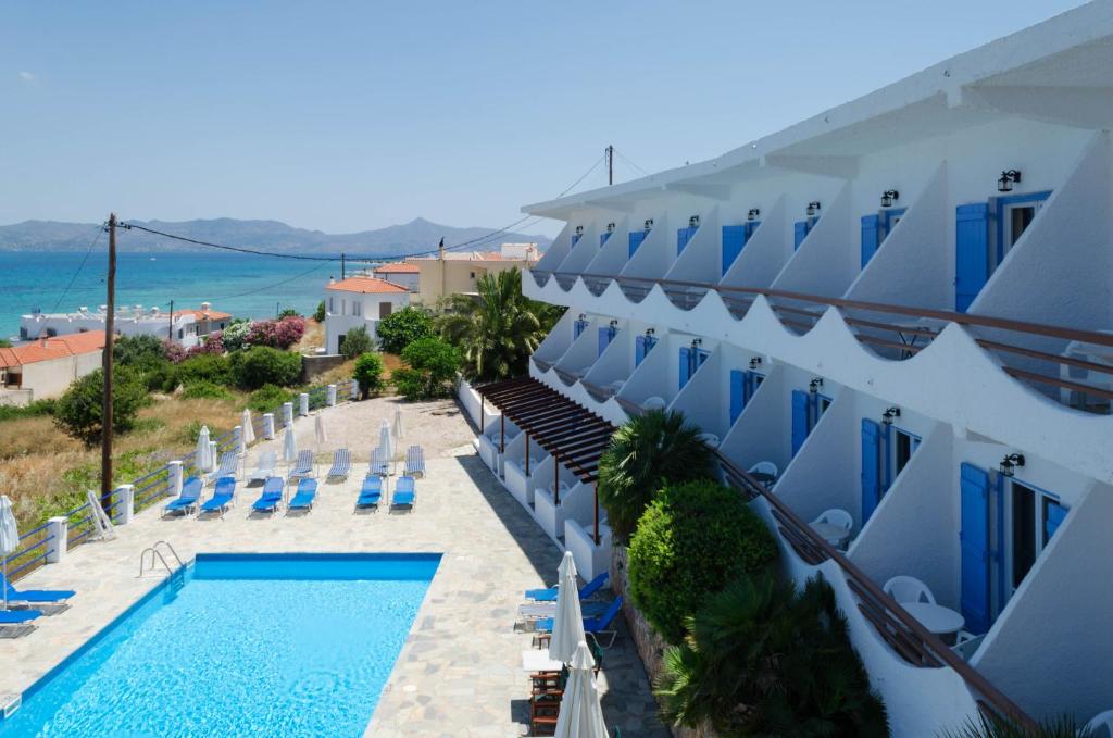 a hotel with a swimming pool next to a building at ''The Boulas'' Rooms in Megalochori