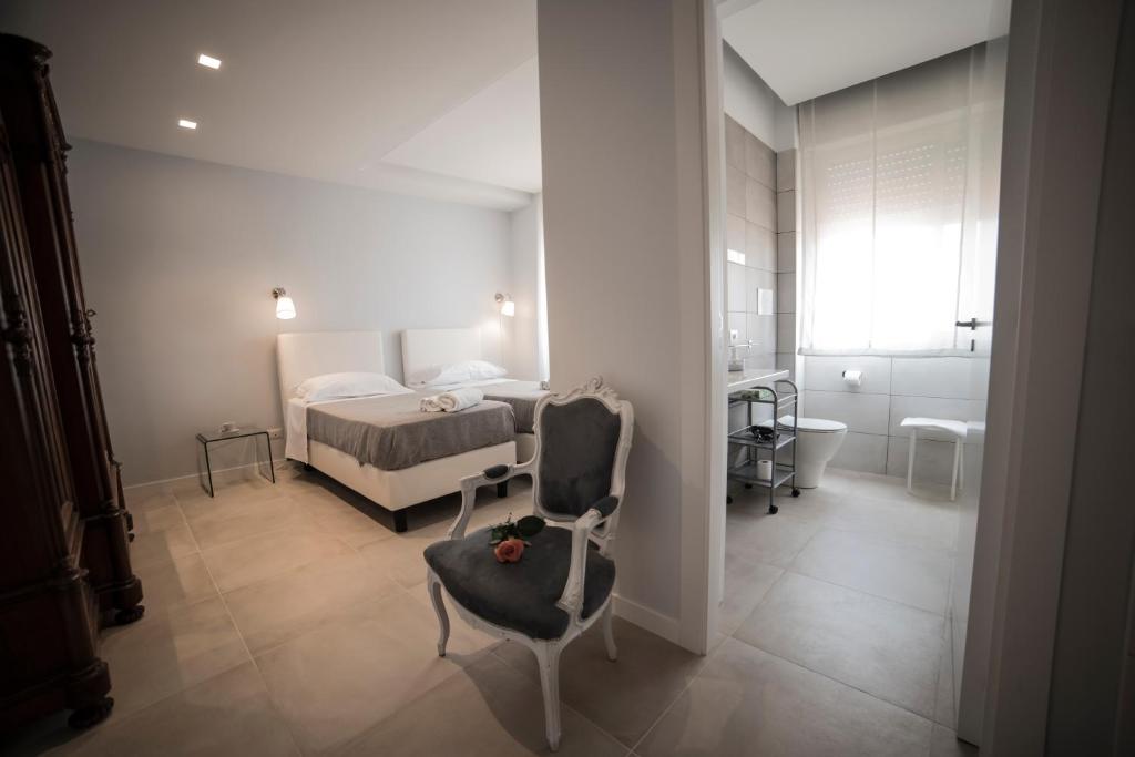 a bedroom with a bed and a chair and a bathroom at B&B Attico 33 in Palermo