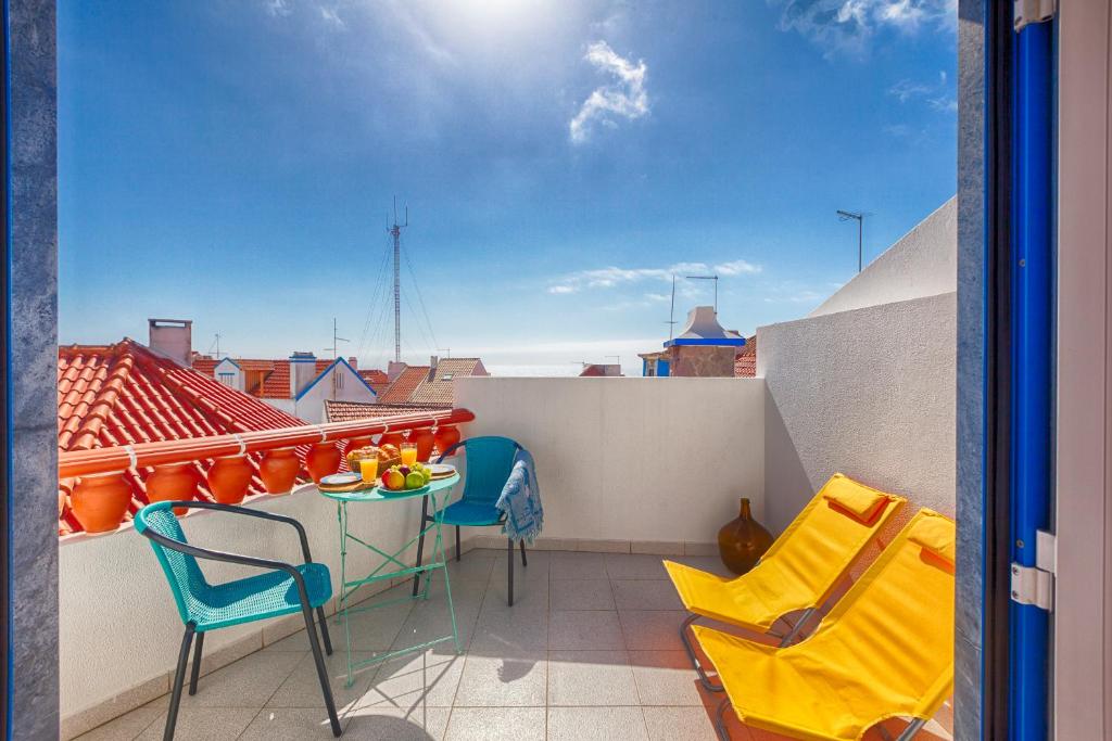 a balcony with a table and chairs on a roof at Like-home Boa Onda House-T4-Ericeira center in Ericeira