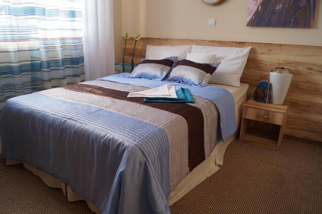 a bedroom with a large bed with a wooden headboard at Villa Amber in Sarbinowo