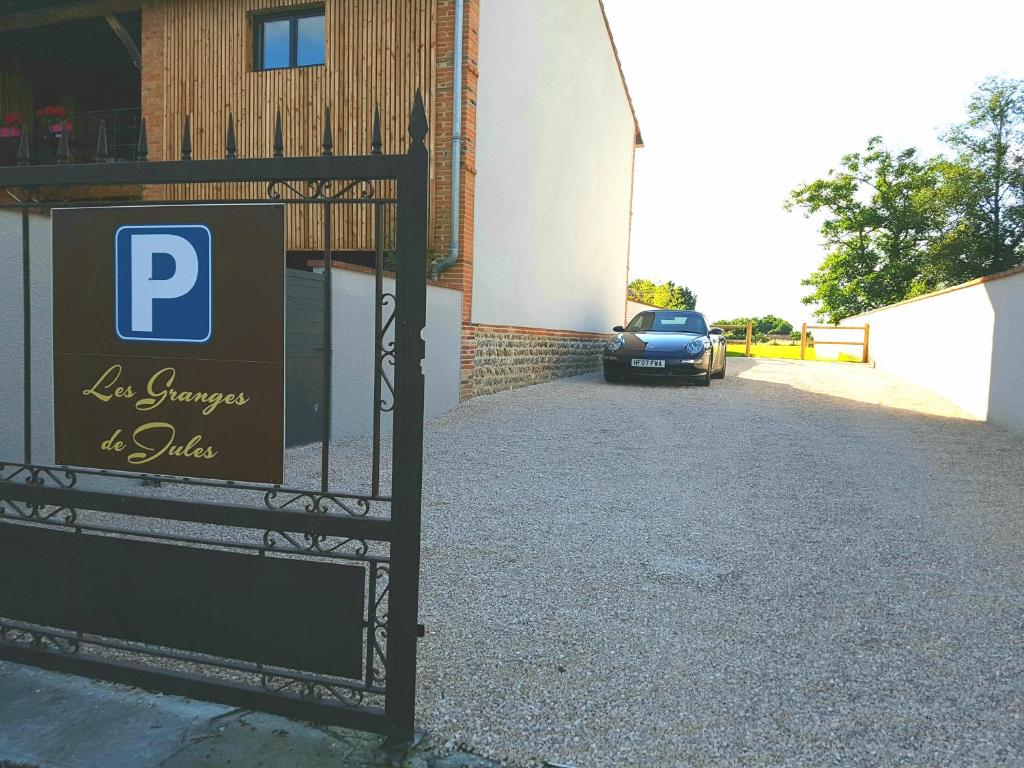 a gate with a parking sign in front of a building at Les Granges de Jules in Lafitte-Vigordanne