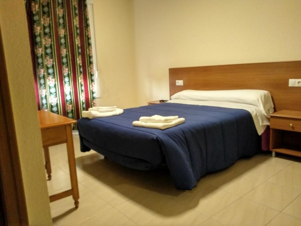 A bed or beds in a room at Hostal Orly