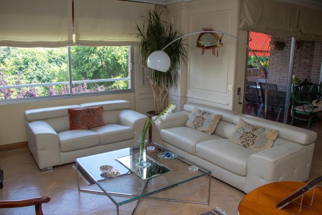 a living room with two couches and a glass table at Modern B&B Somosaguas in Somosaguas